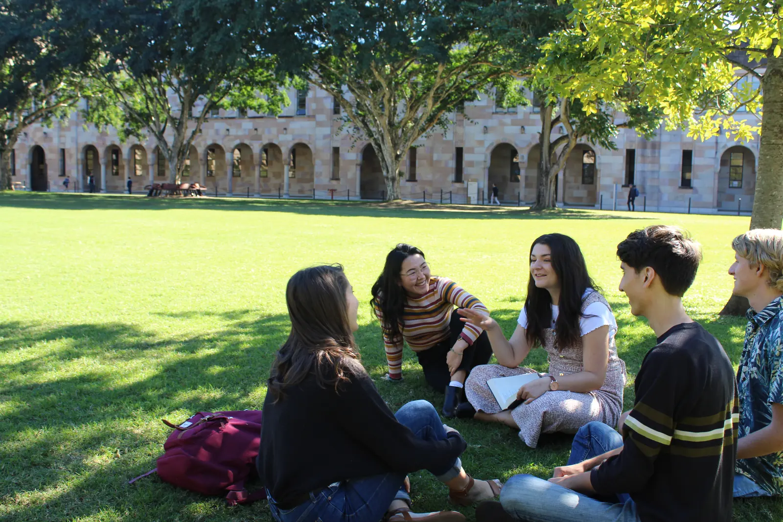 University students talking together on a campus lawn
