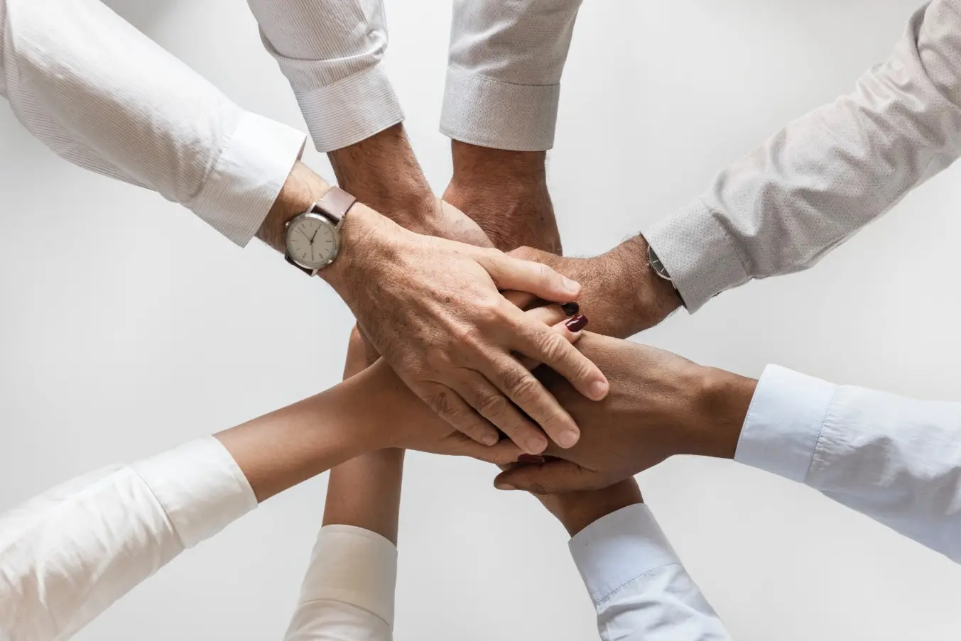 Many hands stacked together, seen from above